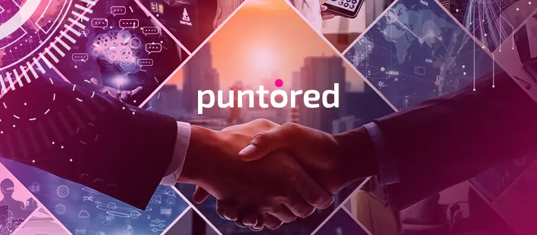 Ejecutivos sellando alianza estratégica con logo de PuntoRed al fondo